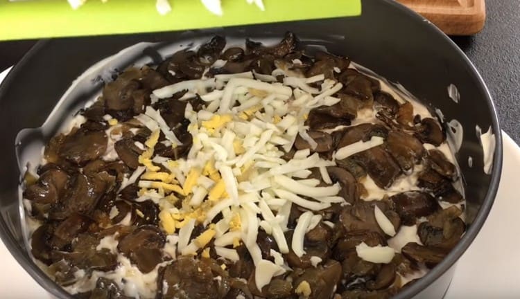 Разтрийте сварените пилешки яйца върху гъбния слой.