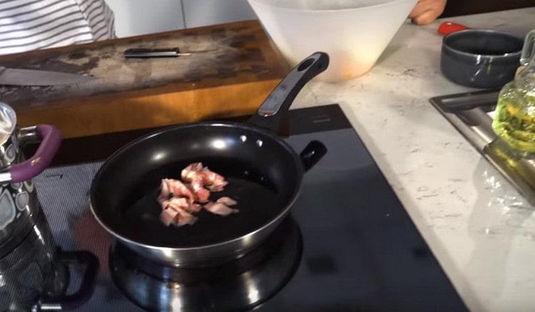 Разстиламе бекона в тиган и го запържваме до получаване на особени чипс.