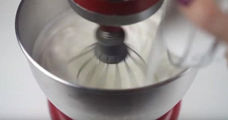 Бавно въведете захарта в белтъците и разбийте до стабилни върхове.