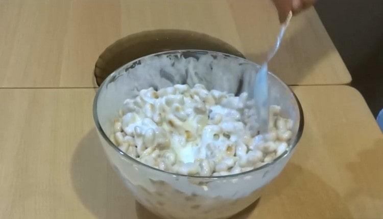 Разстиламе крекери в заквасена сметана.