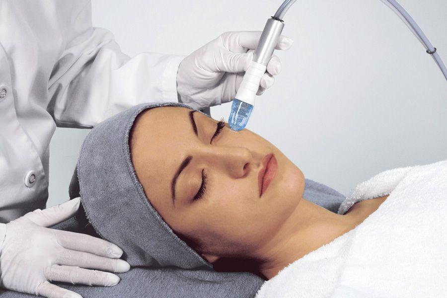 Maître effectue une procédure de microdermabrasion dans un salon de beauté