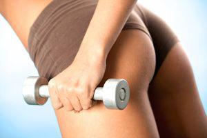 Elastisk kvindelig røv og håndvægt i hænderne