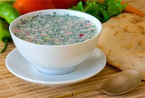 Sommer okroshka in einer weißen tiefen Platte auf dem Tisch