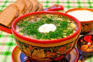 Okrochka dans une assiette creuse en bois avec peinture russe