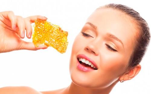 Niña sostiene panales en sus manos.