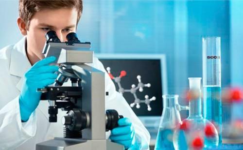 En mand udfører en DNA-test under et mikroskop.