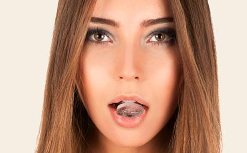 Niña sostiene un cubito de hielo en la boca