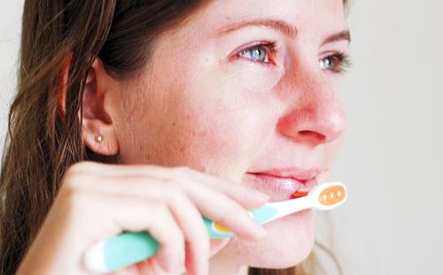 Une fille masse ses lèvres avec un pinceau