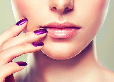 Holder en hånd i hjørnerne på læberne