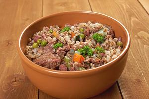 Bol de argilă cu terci pe o masă de lemn