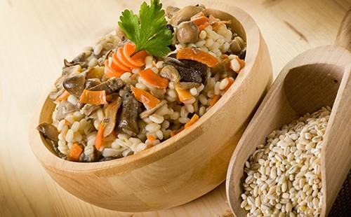 Terci utile de orz cu morcov într-un bol de lemn
