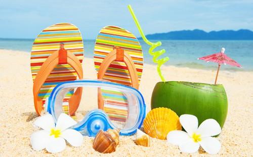 Strand, sand, hjemmesko og kokosnødjuice i kokosnød