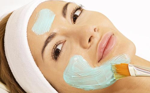 Una mujer de ojos marrones está manchada con una sustancia azul en la cara