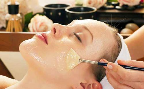 Un masque de glycérine est appliqué sur le visage d'une fille