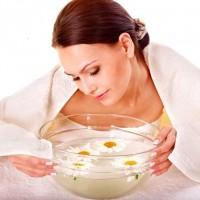 Visage de femme à la vapeur avec bouillon de camomille