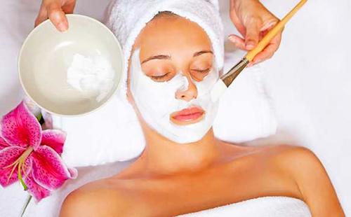 Fille dans une serviette blanche et avec une fleur rose