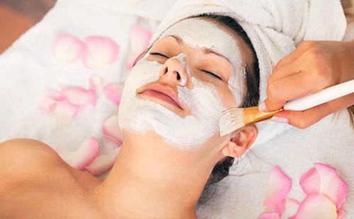 Mélange blanc sur le visage d'une femme et de pétales roses épars