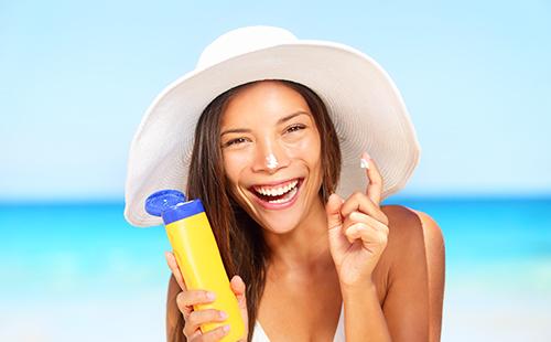 La fille au chapeau barbouilla de la crème sur le nez et rit