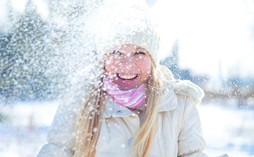 La chica de gorra blanca disfruta de la nieve