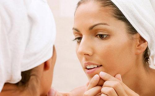 Dívka vymačkává černé tečky na tváři