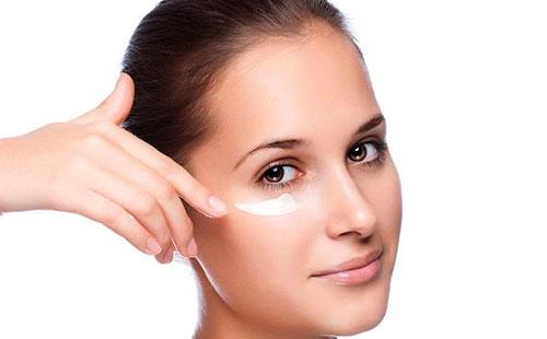 Fille frottis crème sous les yeux