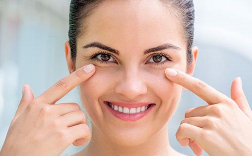 La fille montre la peau sous les yeux