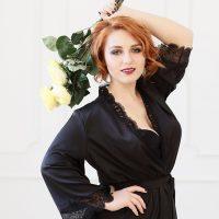 Lisa en seda negra y con un ramo de rosas amarillas.