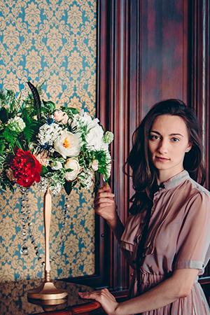 Natalya se penche sur une table avec un bouquet