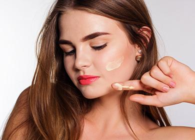 Belle fille avec un frottis de crème sur la joue