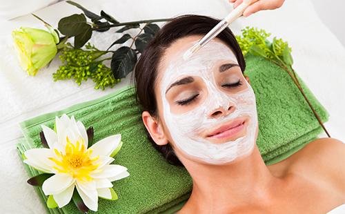 La jeune fille applique un masque blanc sur son visage