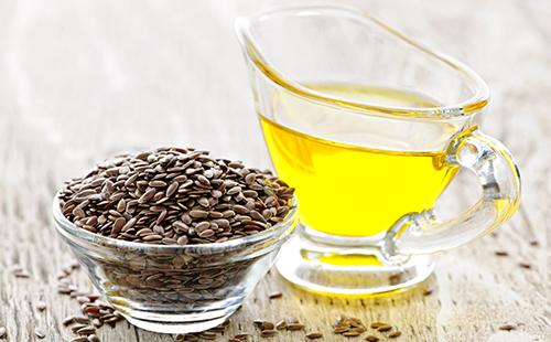 Graines sombres et une tasse d'huile jaune