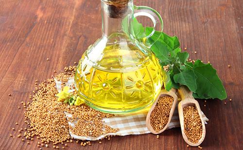 Pichet en verre avec huile de moutarde et graines saupoudrées