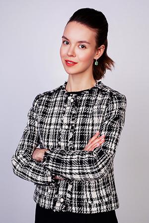 Une femme en veste à carreaux croisa les bras sur sa poitrine.