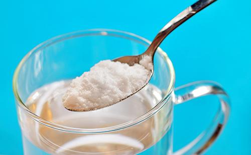 Une cuillère de soda sur un verre d'eau