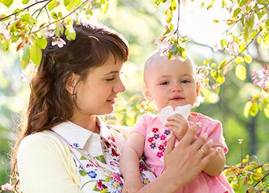Maman et bébé marchent parmi des arbres en fleurs