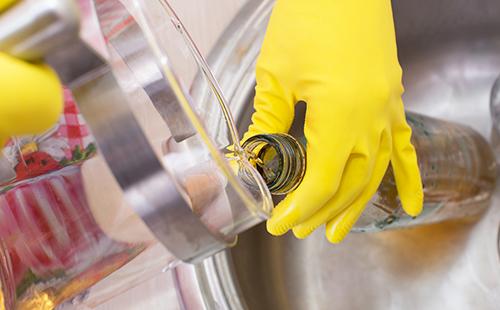 La main dans le gant jaune verse un liquide caustique