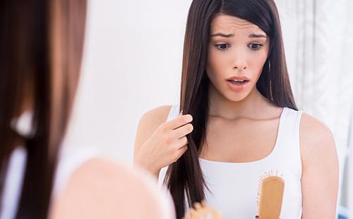 Femme regarde le peigne avec surprise