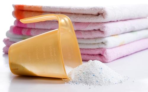 Målekop foran en stak håndklæder