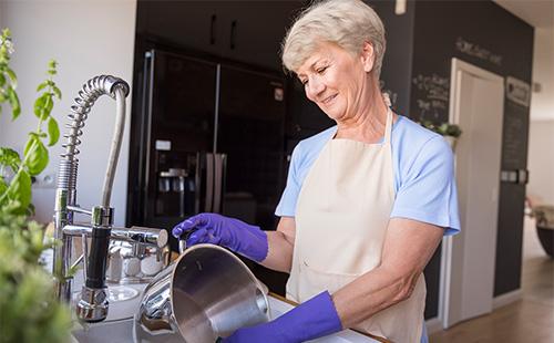 Frau wäscht eine Pfanne