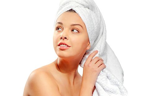 Magandang babae na may tuwalya sa kanyang ulo