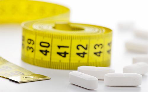 Pilules et centimètre blanc