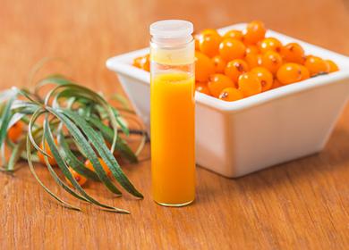 O bulă de ulei de portocale lângă fructe de pădure