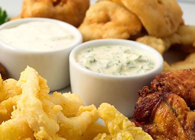 Tigelas com molho picante para rodelas de carne e cebola