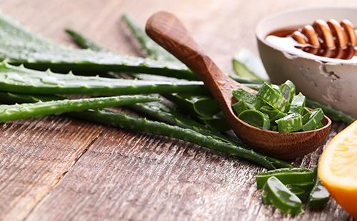 Frunze de aloe într-o lingură de lemn și miere