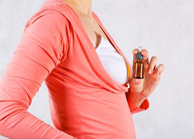 Mujer en la parte superior de salmón sostiene una botella de aceite