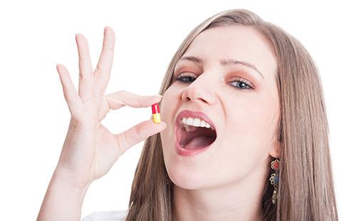 Flicka som ska ta ett piller