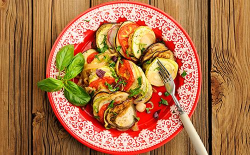Un plat sur une assiette d'aubergines et de tomates aux herbes
