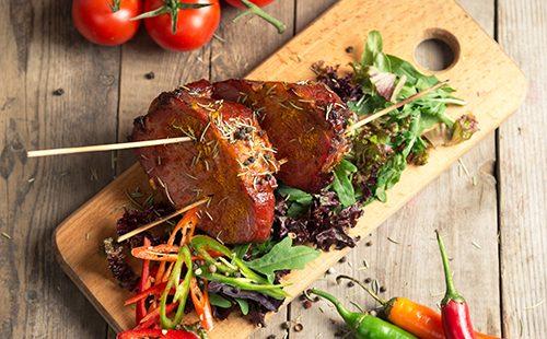 מעשיר חזיר מבושל עם עגבניות ועשבי תיבול