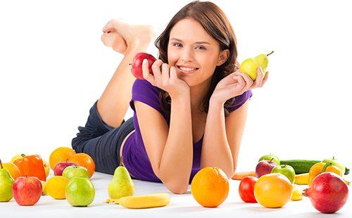 Fille tient une pomme et une poire