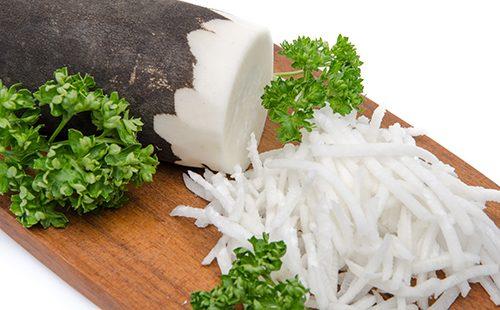 Strouhané černé ředkvičky na desce